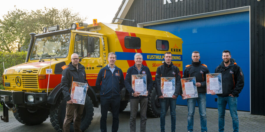De oorkonde voor bemanning KNRM Ameland met KNRM-directeur Jacob Tas.